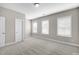 A bright bedroom with neutral carpet, three bright windows and a door at 32 Iroquois Ct, Garner, NC 27529