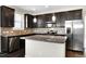 Modern kitchen with dark cabinets, a granite-topped island, and stainless steel appliances at 32 Iroquois Ct, Garner, NC 27529