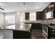 Open kitchen with a large island, dark cabinets, stainless steel appliances, and dark wood floors at 32 Iroquois Ct, Garner, NC 27529
