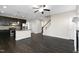 Open-concept living room with dark wood floors, fireplace, and staircase views at 32 Iroquois Ct, Garner, NC 27529
