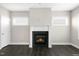 Cozy living room showcasing a fireplace, dark wood floors, and bright windows at 32 Iroquois Ct, Garner, NC 27529