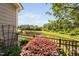 Picturesque backyard with a black metal fence, landscaped bushes, and a view of a tranquil pond at 323 Rosedale Creek Dr, Durham, NC 27703