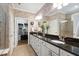 Double vanity with dark granite countertop, contrasting white cabinetry, and decorative wallpaper at 323 Rosedale Creek Dr, Durham, NC 27703
