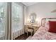 Vanity with antique mirror and chair, illuminated by lamps on either side of the mirror at 323 Rosedale Creek Dr, Durham, NC 27703