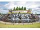 Grand community entrance with a rock waterfall and attractive landscaping at 323 Rosedale Creek Dr, Durham, NC 27703