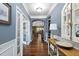 Elegant hallway featuring hardwood floors, wainscoting, an arched doorway, and stylish decor at 323 Rosedale Creek Dr, Durham, NC 27703