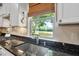 Bright kitchen featuring a stainless steel sink with a window view of lush greenery and a pond at 323 Rosedale Creek Dr, Durham, NC 27703