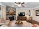 Comfortable living room with a stone fireplace, hardwood floors, ceiling fan, and comfortable furniture at 323 Rosedale Creek Dr, Durham, NC 27703