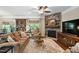 Cozy living room featuring stone fireplace, hardwood floors, a ceiling fan, and comfortable furniture at 323 Rosedale Creek Dr, Durham, NC 27703