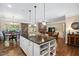 Open-concept layout with kitchen island, dining area, and living room featuring a stone fireplace at 323 Rosedale Creek Dr, Durham, NC 27703