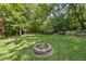 Expansive backyard with a stone fire pit and lush green lawn, ideal for outdoor activities and gatherings at 3412 Paddock Cir, Raleigh, NC 27613