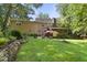 Expansive backyard with a patio, fire pit, stone garden beds, and lush green lawn, ideal for outdoor entertaining at 3412 Paddock Cir, Raleigh, NC 27613