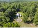Aerial view of barns and adjacent pastures surrounded by dense trees, showcasing expansive land at 3412 Paddock Cir, Raleigh, NC 27613