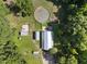 Aerial view showcasing metal barn with surrounding green pastures, featuring rural charm and functionality at 3412 Paddock Cir, Raleigh, NC 27613