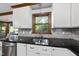 White kitchen cabinets with gray marble backsplash, wood trim, and stainless appliances at 3412 Paddock Cir, Raleigh, NC 27613
