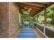 Inviting screened porch with brick accent wall, wicker furniture, ceiling fan, skylight, and backyard views at 3412 Paddock Cir, Raleigh, NC 27613