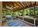 Inviting screened porch with wicker furniture, ceiling fan, skylight, and view of the private wooded backyard at 3412 Paddock Cir, Raleigh, NC 27613