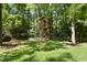 Charming backyard treehouse surrounded by mature trees and lush greenery, a perfect hideaway for children at 3412 Paddock Cir, Raleigh, NC 27613