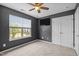 Cozy bedroom with a ceiling fan, neutral carpet, and a large window at 3526 Londonville Ln, Raleigh, NC 27604