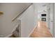 Hallway with hardwood floors leads to living area with a fireplace and plush carpet on stairs at 3526 Londonville Ln, Raleigh, NC 27604