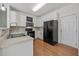 An efficient kitchen featuring white cabinets, black appliances, and wood look flooring at 3526 Londonville Ln, Raleigh, NC 27604