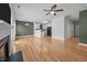 A living room with hardwood floors open to the kitchen area and featuring a cozy fireplace at 3526 Londonville Ln, Raleigh, NC 27604