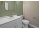 Stylish powder room featuring a modern vanity, elegant wallpaper, and golden fixtures at 3526 Londonville Ln, Raleigh, NC 27604
