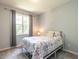 Cozy bedroom features a metal-framed bed with a floral comforter, a window, and grey carpeting at 3709 Andoversford Ct, Wake Forest, NC 27587