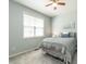 Comfortable bedroom featuring a large window for natural light and light blue wall paint at 3709 Andoversford Ct, Wake Forest, NC 27587