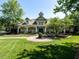 Beautiful clubhouse with inviting porch, stone pillars, lush landscaping and sidewalk at 3709 Andoversford Ct, Wake Forest, NC 27587