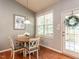 Cozy dining nook features hardwood floors, a round table, a light fixture, and access to an outdoor deck at 3709 Andoversford Ct, Wake Forest, NC 27587