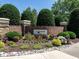 Community entrance with landscaped sign surrounded by colorful flowers and manicured shrubbery at 3709 Andoversford Ct, Wake Forest, NC 27587