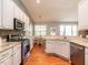 Bright kitchen with stainless steel appliances, stone backsplash, granite counters, and a view into dining nook at 3709 Andoversford Ct, Wake Forest, NC 27587
