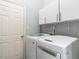Well-equipped laundry room features white washer and dryer units and a storage cabinet at 3709 Andoversford Ct, Wake Forest, NC 27587
