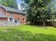 Large backyard with a lawn and a wooden deck attached to a brick house at 408 Greenfern Ct, Burlington, NC 27215