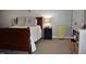 Bedroom featuring a wooden sleigh bed, neutral walls, and a black nightstand with a table lamp at 408 Greenfern Ct, Burlington, NC 27215