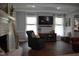 Stylish living room with modern decor, featuring hardwood floors and a white brick fireplace at 408 Greenfern Ct, Burlington, NC 27215