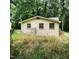 Back view of a house with light siding, surrounded by green trees and lawn at 4112 Forrest Ave, Efland, NC 27243