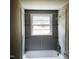 Bathroom features a large window, bathtub, and glass floating shelves at 4112 Forrest Ave, Efland, NC 27243