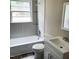 Bright bathroom featuring a bathtub, floating shelves, and modern sink at 4112 Forrest Ave, Efland, NC 27243