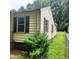 Home exterior featuring light siding, brown shutters, and a view of the yard at 4112 Forrest Ave, Efland, NC 27243