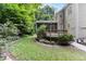 Landscaped backyard featuring a screened porch, a deck, and mature trees at 4305 Heathgate Ln, Raleigh, NC 27613