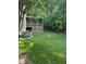 Expansive backyard with lush green grass, mature trees, and a screened porch at 4305 Heathgate Ln, Raleigh, NC 27613