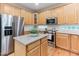 Bright kitchen with stainless steel appliances, granite counters, a kitchen island, and wooden cabinetry at 4305 Heathgate Ln, Raleigh, NC 27613