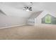 A spacious bonus room featuring an alcove window, built in shelving, carpet, and a ceiling fan at 4924 Zebulon Rd, Zebulon, NC 27597