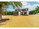 Beautiful exterior view of a well-manicured home with a combination of brick and siding, surrounded by mature trees at 4924 Zebulon Rd, Zebulon, NC 27597