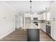 A white kitchen featuring a black island with a marble countertop and stainless steel appliances at 4924 Zebulon Rd, Zebulon, NC 27597
