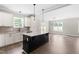 Open kitchen with white cabinets, stainless steel appliances, granite countertop, and wood flooring at 4924 Zebulon Rd, Zebulon, NC 27597