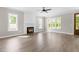 Open-concept living room featuring wood floors, a modern fireplace, and large windows for plenty of sunlight at 4924 Zebulon Rd, Zebulon, NC 27597