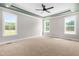 A bright and open main bedroom with recessed lighting, three windows, neutral walls, and carpet at 4924 Zebulon Rd, Zebulon, NC 27597